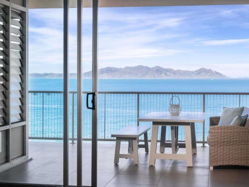 Nelly BayにあるGrand Mercure Apartments Magnetic Islandの海の景色を望むバルコニー(テーブル付)