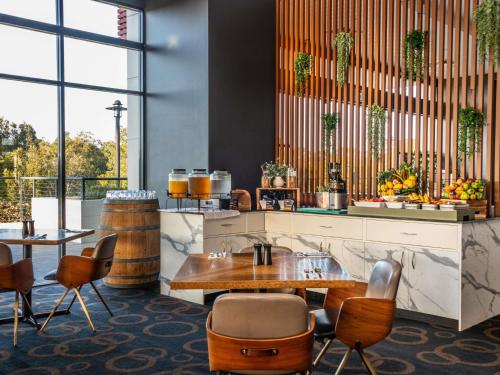 Un restaurante con una mesa y sillas en una habitación. en Mercure Kooindah Waters Central Coast, en Wyong