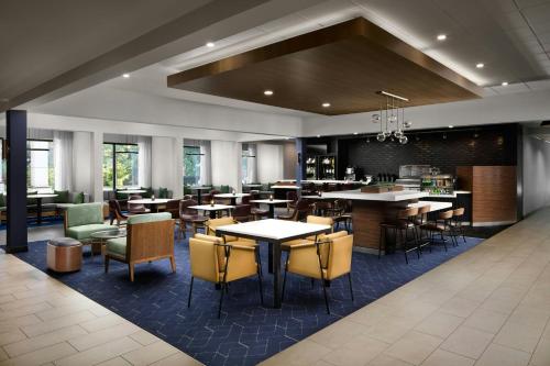 a restaurant with tables and chairs and a bar at Courtyard Williamsburg - Busch Gardens in Williamsburg