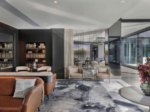 a living room with a couch and chairs and a table at Sofitel Auckland Viaduct Harbour in Auckland