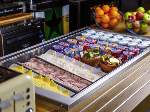 Un refrigerador lleno de comida y fruta en un mostrador. en ibis budget Hotel Edinburgh Park, en Edimburgo