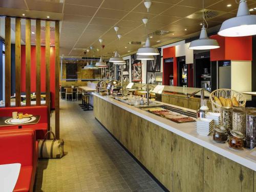 um restaurante de fast food com um balcão longo com comida em Ibis Hamburg City em Hamburgo