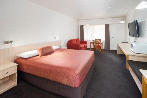 Habitación de hotel con cama y TV en Box Hill Motel, en Burwood