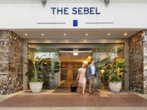 a couple walking in front of a seelel store at The Sebel Brisbane in Brisbane