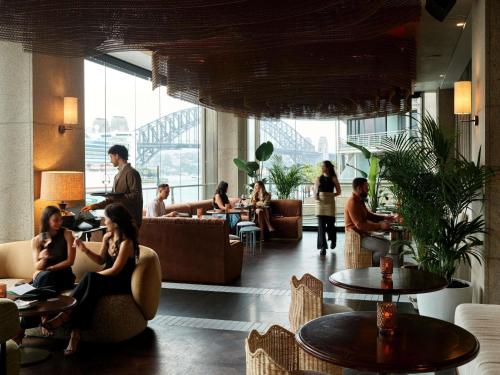 a group of people sitting in a restaurant at Pullman Quay Grand Sydney Harbour in Sydney