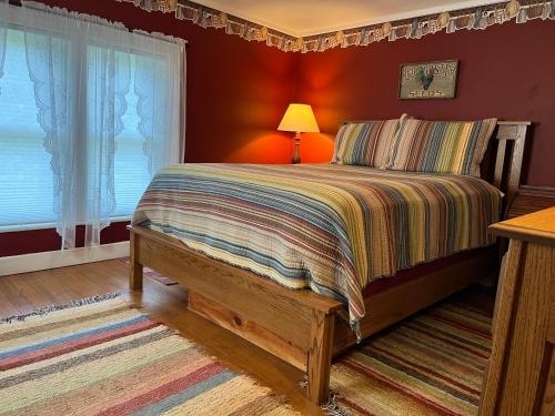 a bedroom with a bed with red walls at Rainbow Ridge Farms in Onalaska