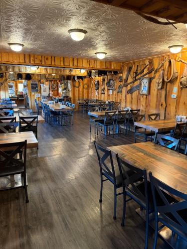 Un comedor con mesas y sillas de madera. en Frontier Lodge, en Lander