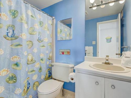 a blue bathroom with a toilet and a sink at Coops Retreat Unit B in Tybee Island