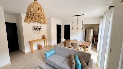 a living room with a couch and a dining room at New apartment with 3 bedrooms, for 6 persons & 7 min from Maya train in Cancún