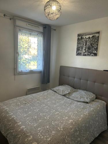 un dormitorio con una cama y una ventana en T2 cosy et calme, en Toulouse