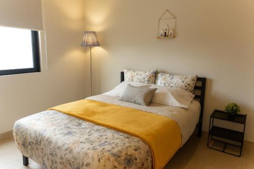 a bedroom with a large bed with a yellow blanket at Departamento 3er Nivel ideal para Catrinas in Atlixco