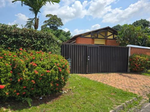 a house with a black fence and some flowers at Wonderful lakefront house in a luxury condominium - Ananindeua in Ananindeua