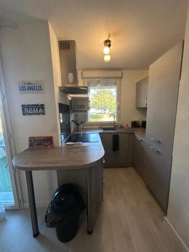a kitchen with a wooden table in a room at T2 cosy, calme et 2 Parking privé avec Piscine in Toulouse