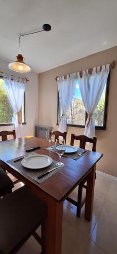 a dining room table with wine glasses on it at Cabañas Paso de Viento in El Chalten