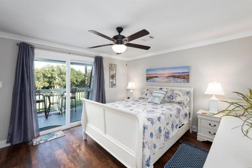 a bedroom with a bed and a ceiling fan at Driftwood Villa 256 - Slo Drift in Edisto Island