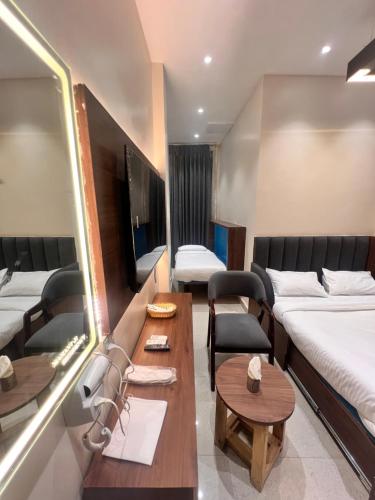 a hotel room with two beds and a table at Mahant Ji Residency in Varanasi
