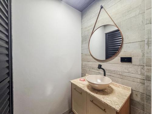 a bathroom with a sink and a mirror on the wall at Casa em bairro nobre + 3 quartos com ar e 2 vagas in Ourinhos