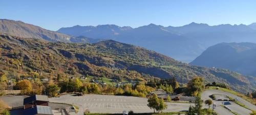 a view of a valley with mountains in the background at appartement cozy au pied des pistes in Le Corbier