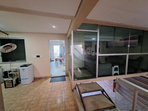 un salon avec une grande paroi en verre dans l'établissement Casa Confortável no bairro Cabral - Contagem MG, à Contagem