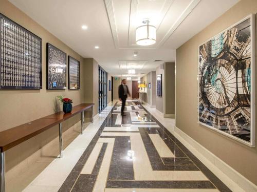 un hombre caminando por un pasillo en un edificio en The Artisan Hotel Istanbul - MGallery Collection, en Estambul