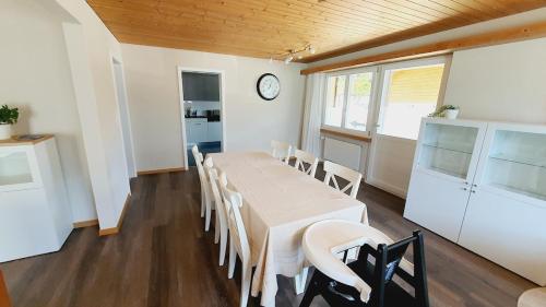 OberriedにあるApartment by Lake Brienz with lake viewのテーブルと椅子と時計のあるダイニングルーム