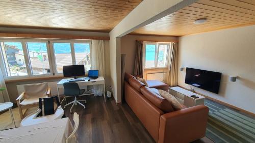 OberriedにあるApartment by Lake Brienz with lake viewのリビングルーム(ソファ、デスク、コンピュータ付)