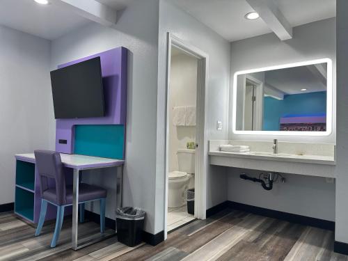 y baño con mesa, lavabo y espejo. en Fountain Inn Motel - Alhambra, Los Angeles, en Alhambra