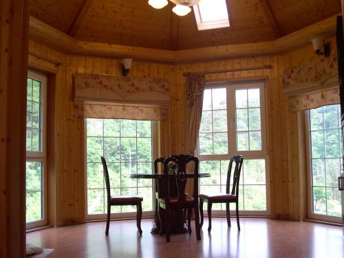 een eetkamer met ramen en een tafel en stoelen bij Happy Dream Pension in Pyeongchang 