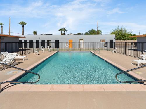 a large swimming pool with chairs and a building at Mirage Apartments in Phoenix