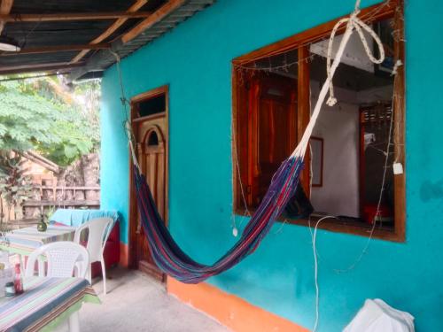 カプルガナにあるHostal el Profeのハンモックが掛けられた青い家