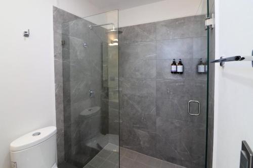 um banheiro com chuveiro com porta de vidro em Beautiful and New Bahía Serena Condominium em Isla Cardones