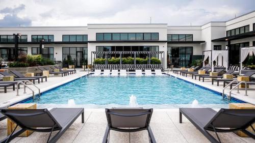 a large swimming pool with chairs and a building at Midtown Luxury with Skyline Views in Atlanta