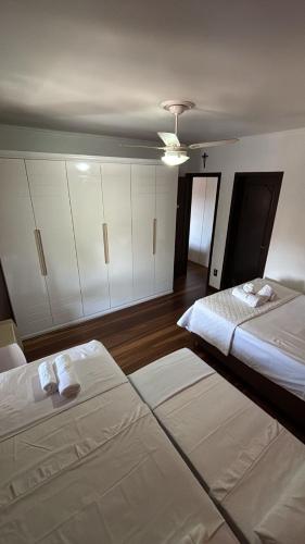 two beds in a room with white cabinets at Apartamento Canoas RS in Canoas