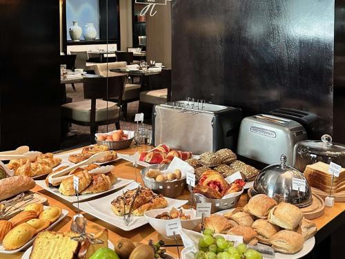 einen Tisch mit verschiedenen Brotsorten und Gebäck in der Unterkunft Park Hotel Grenoble - MGallery Collection in Grenoble