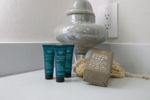 a counter with two toothbrushes and a light switch and a book at Elegant Naples Studio with Huge Bathroom in Naples