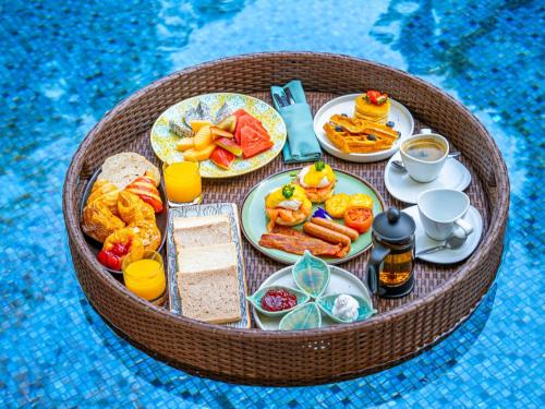 a tray of breakfast foods and drinks on a table at SO/ Sofitel Hua Hin in Cha Am