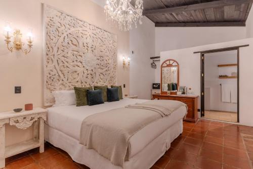 a bedroom with a large bed and a chandelier at Conceptio in San Pedro Las Huertas
