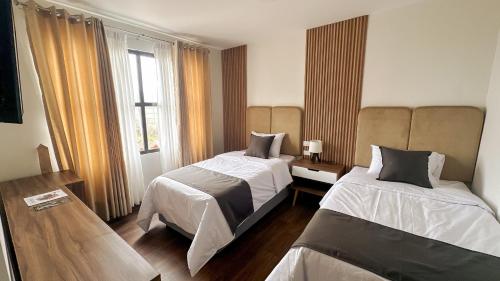 HuauraにあるBarón de Huaura Hotel Boutiqueのベッド2台と窓のある寝室
