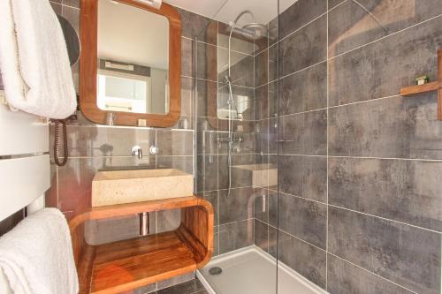 a bathroom with a sink and a shower at Logis Hôtel - Le Manoir de Sauvegrain in Saint-Lambert