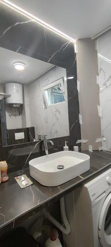 a bathroom with a white sink and a mirror at Republic square central in Belgrade