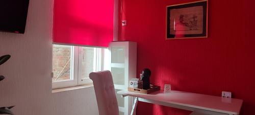 a room with a red wall with a table and a window at Republic square apartment in Belgrade