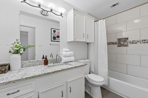 een witte badkamer met een wastafel en een toilet bij Vibrant 3BR Dallas Home, Near DFW, With Family-Friendly Amenities in Irving