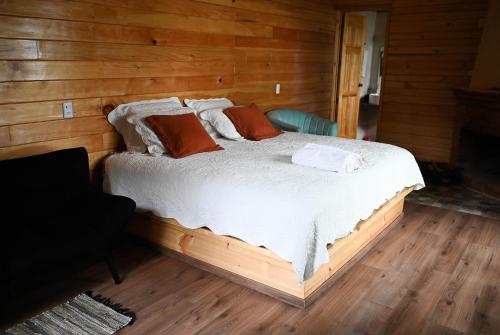 a bedroom with a bed in a wooden room at San José del Pacífico- Cabañas Camino al Cielo 2 in San Mateo Río Hondo