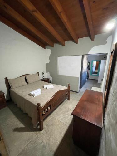 a bedroom with a bed and a wooden ceiling at Sierra Chica in Alta Gracia