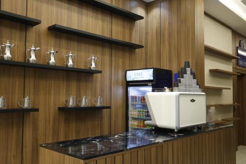 a coffee shop with a drink machine on a counter at راديكس ميلينيوم Radix Millennium in Ar Ruwanah