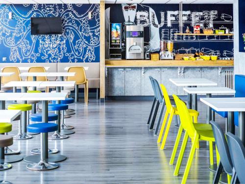 een restaurant met gele stoelen en tafels en een bar bij Ibis Budget Fréjus St Raphaël centre in Fréjus