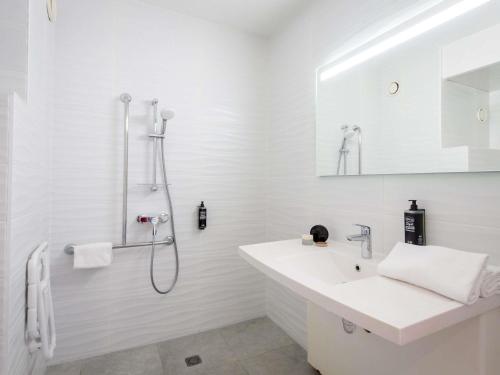 a white bathroom with a sink and a shower at Ibis Budget Fréjus St Raphaël centre in Fréjus
