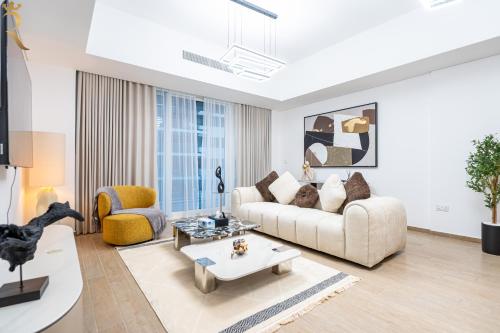 a living room with a couch and a table at Stylish 2BR - Grand Royale Elegant Escape in Abu Dhabi