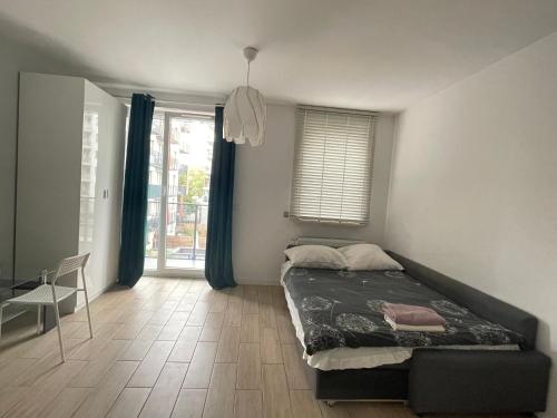 Un dormitorio con una cama y una silla y una ventana. en cybernetyki2 INN near airport, en Varsovia