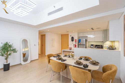 a dining room and kitchen with a table and chairs at Stylish 2BR - Grand Royale Elegant Escape in Abu Dhabi
